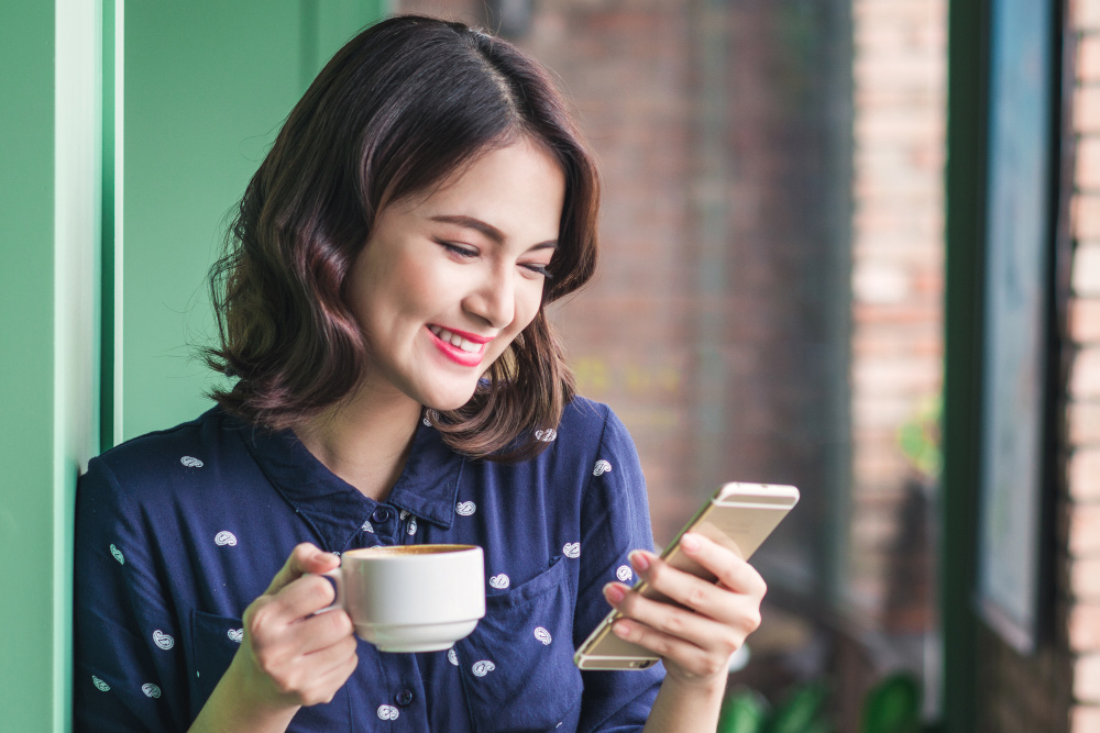 Woman with a coffee using a phone app