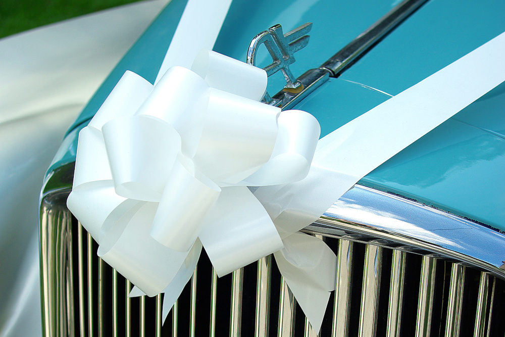A white ribbon tied on a wedding car