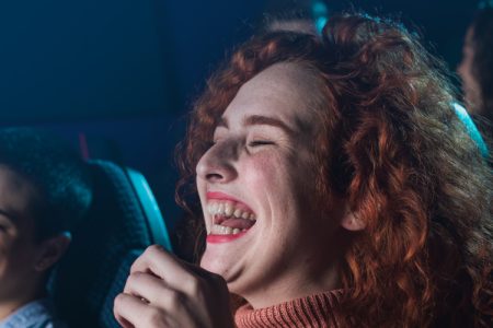 Group of friends laughing in the cinema audience