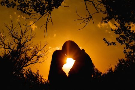 Silhouette of romantic couple against orange background
