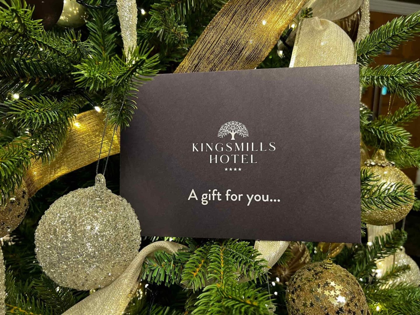 Kingsmills Gift Voucher tucked into a Christmas Tree decorated in gold.
