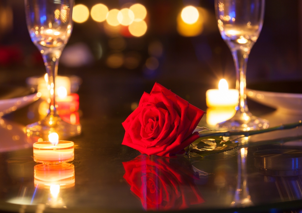 Wine glasses and a red rose on the dinner table