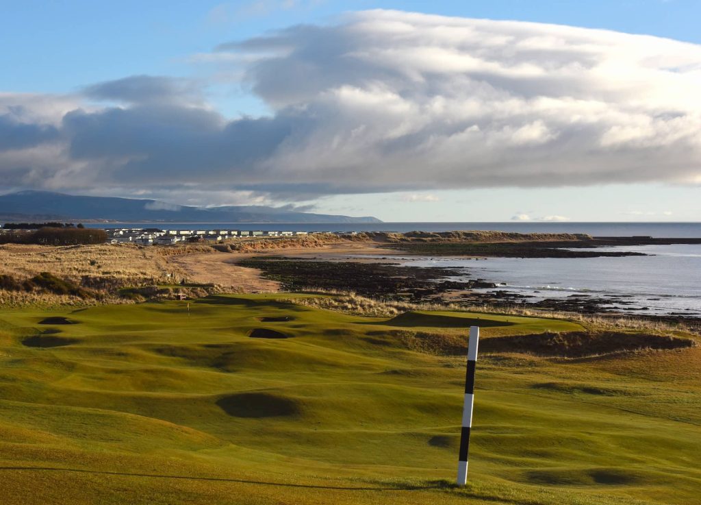 Royal Dornoch Golf Course with hole in foreground and sea in distance