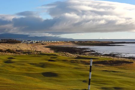 Royal Dornoch Golf Course with hole in foreground and sea in distance