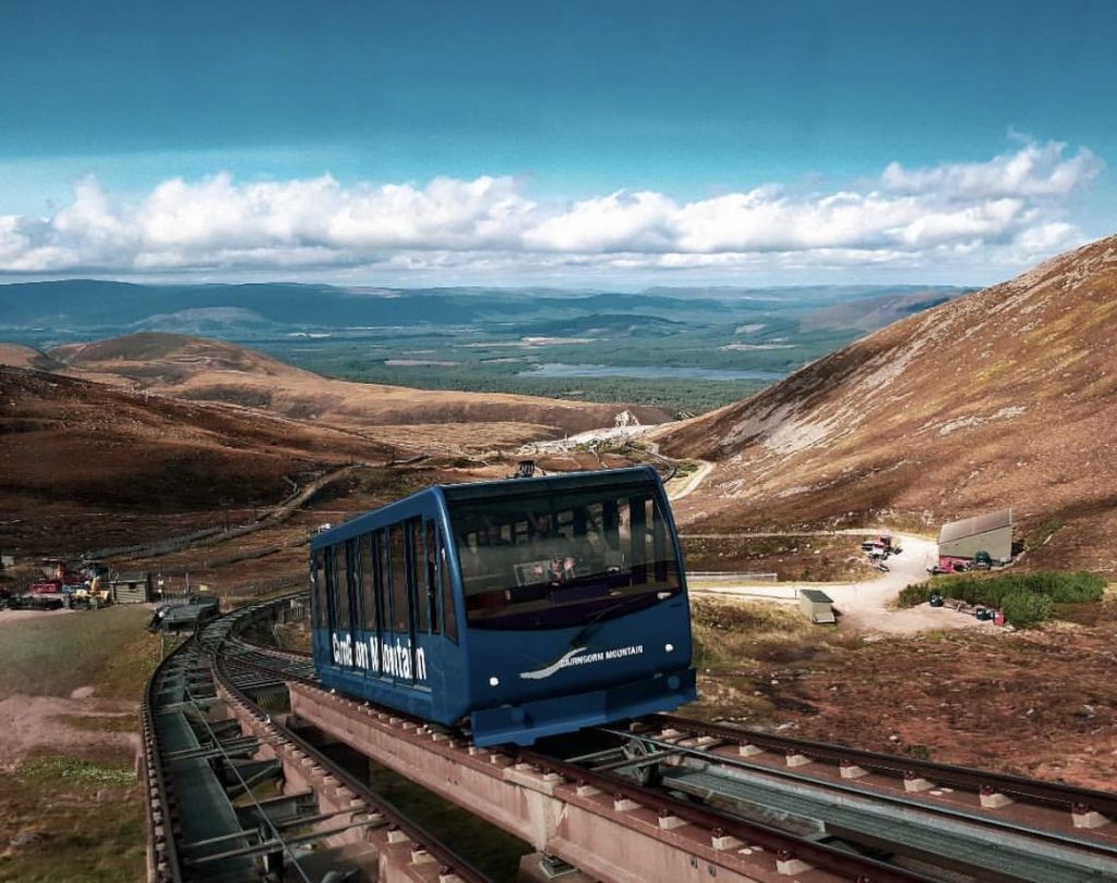 Cairngorm funicular railway heading up the Cairngorm Mountains with blue sky in the background