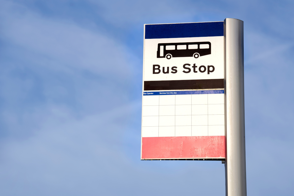 Bus stop sign against a blue sky