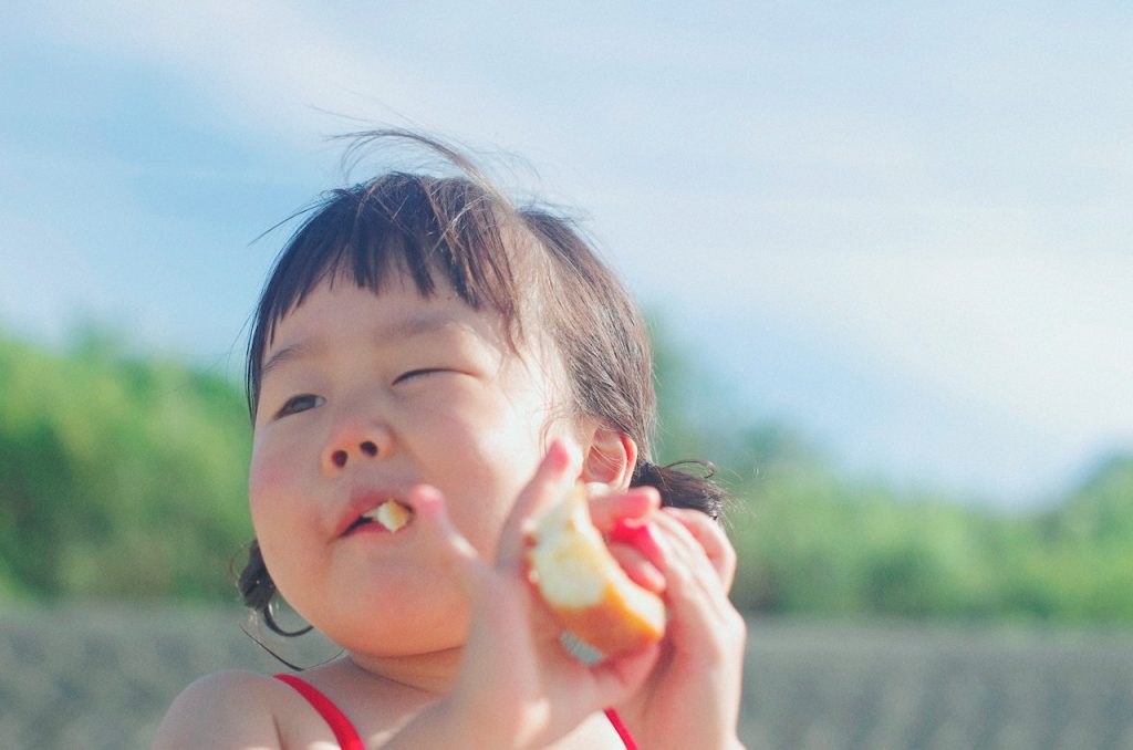 Young child eating snack in the gardens