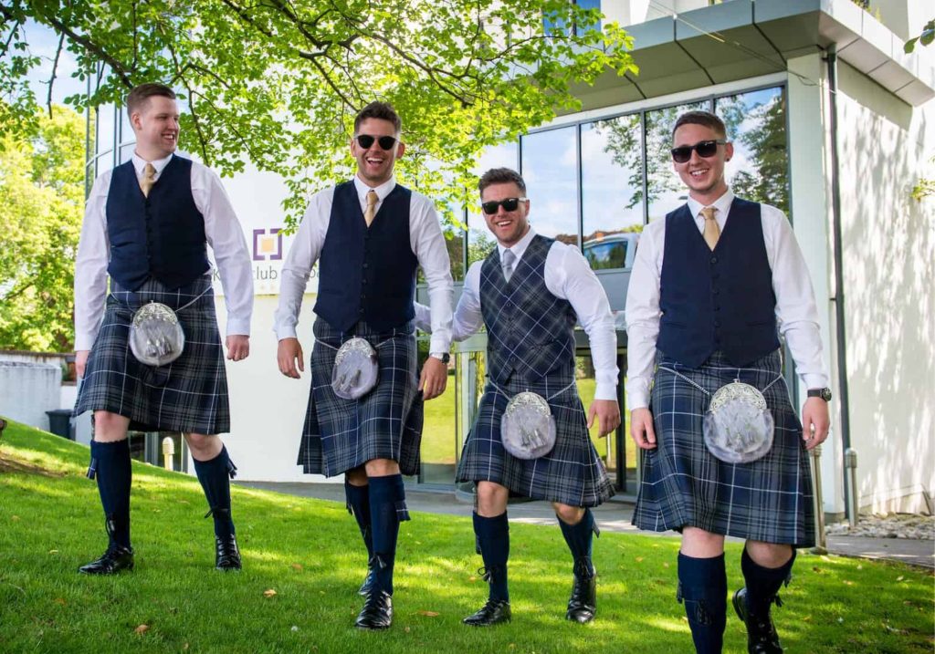 Groomsmen outside the Kingsclub building on lawn