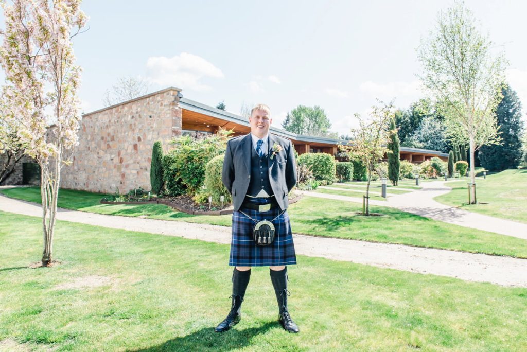 Groom standing in gardens credit Karen Thorburn