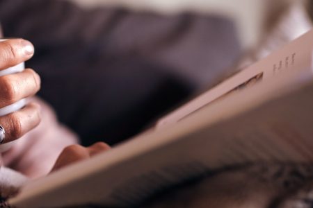 Woman reading a book with a hot drink