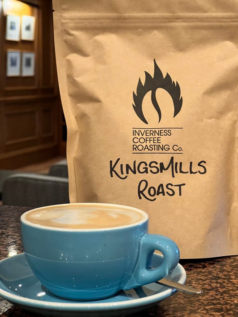 Coffee cup in the Kingsmills lounge with a bag of exclusive blend beans from Inverness Coffee Roasting