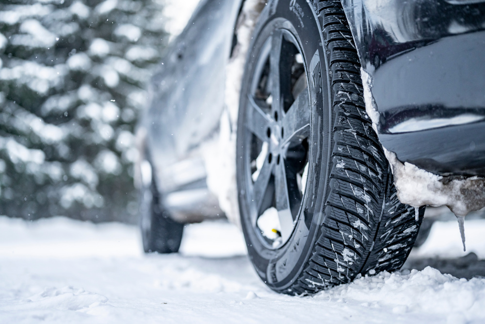 Close up of winter tyres on a car, snowy day.
