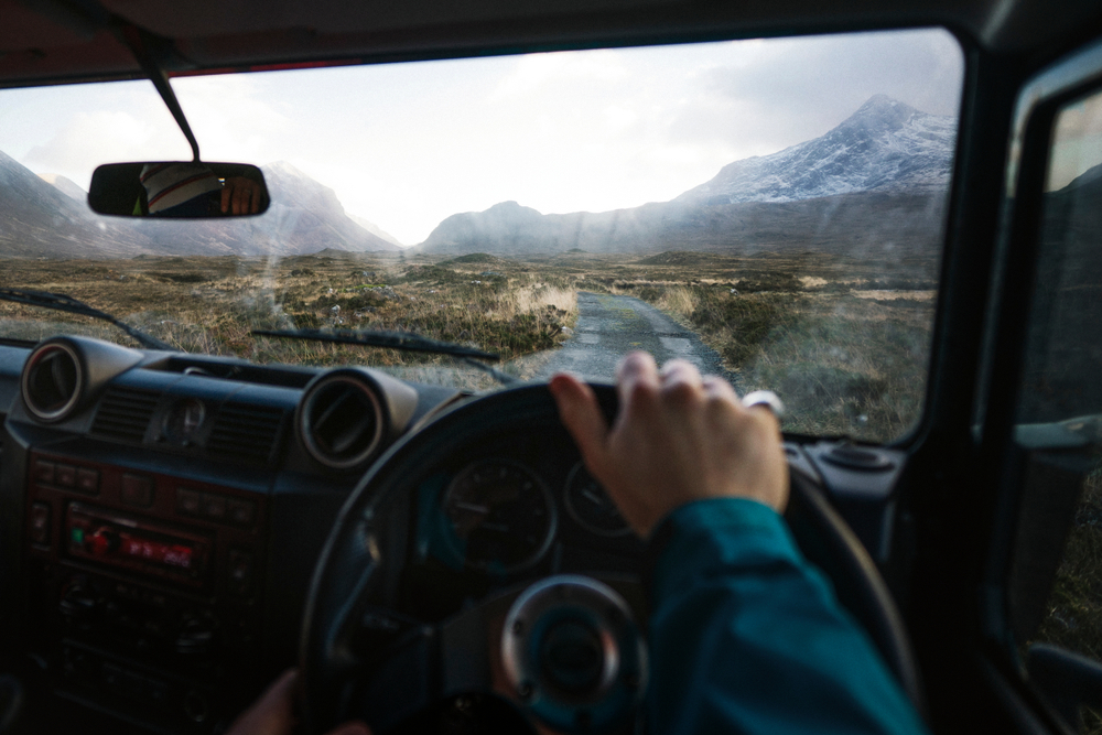 Man driving a car in the Highlands, Scotland