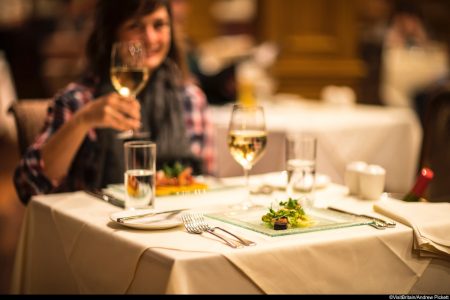 Lady raising a glass of wine during dinner in the Conservatory at the Kingsmills Hotel