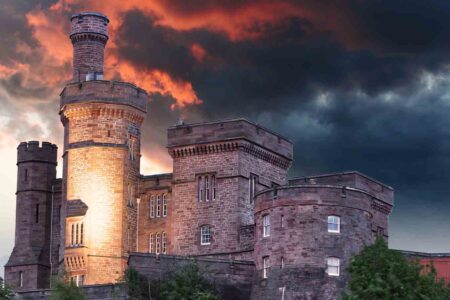Inverness Castle at sunset with red sky behind it.