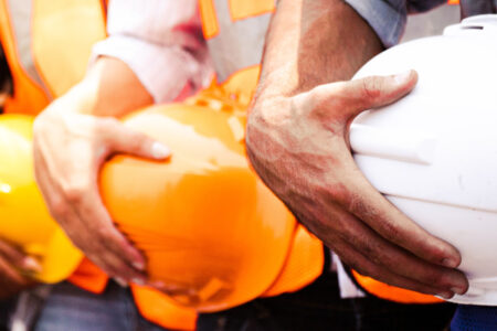 Engineer team holding hardhat standing in row