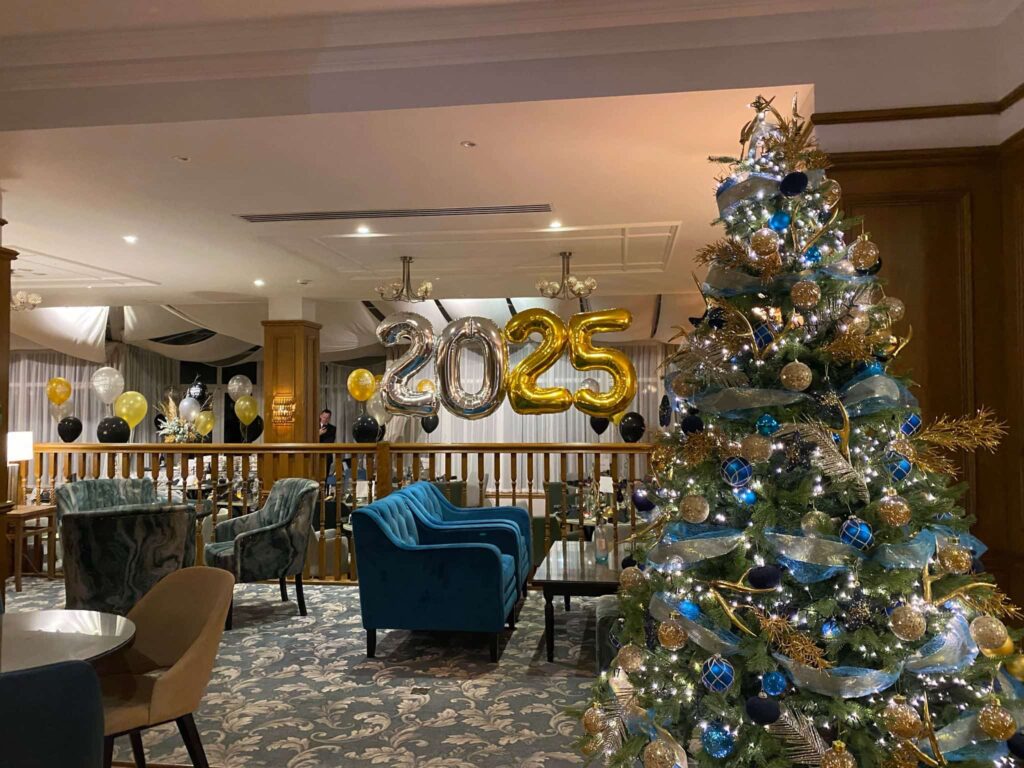 Hogmanay in the Conservatory with 2025 foil balloons and a Christmas Tree